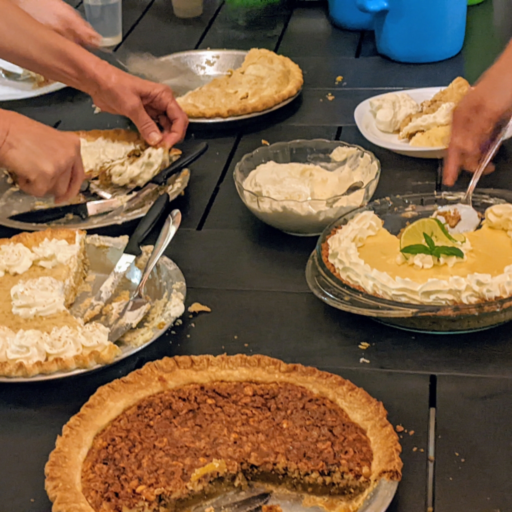 hands serving various kinds of pie